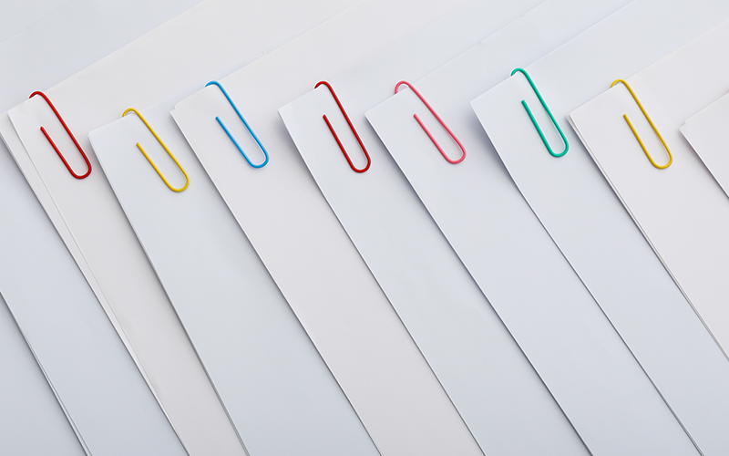 multiple stacks of paper held together with colourful paper clips